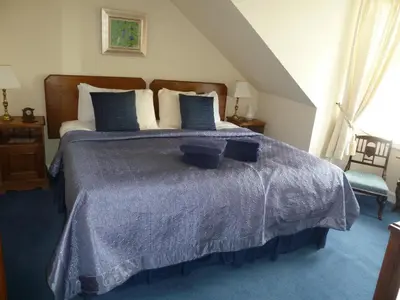 a bedroom with a bed with a blue comforter at Burnside Guest House in Ayr