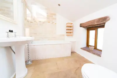 a bathroom with a sink and a bath tub at The Nook Cottage in Carlisle
