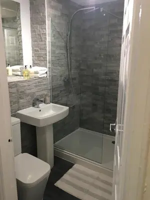a bathroom with a shower and a sink and a toilet at The Nook - Coorie Doon in Ayr