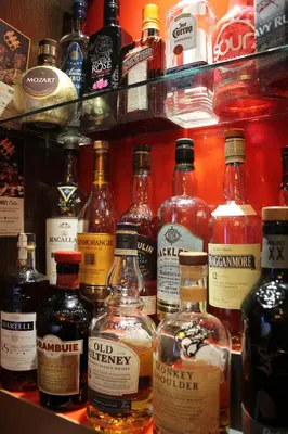 a shelf filled with lots of bottles of alcohol at The Kirkcudbright Bay Hotel in Kirkcudbright