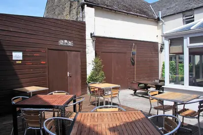 an outdoor patio with tables and chairs and a building at The Kirkcudbright Bay Hotel in Kirkcudbright