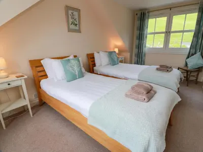 a bedroom with two beds with towels on them at Cairnhill in Girvan