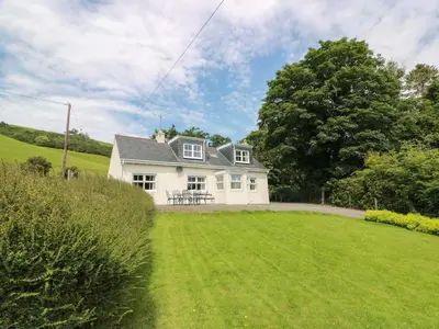 a white house with a large grassy yard at Cairnhill in Girvan
