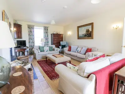 a living room with white couches and a table at Marl House in Newton Stewart