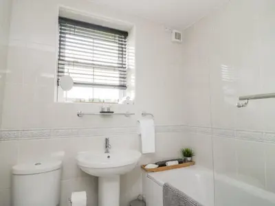 a white bathroom with a toilet and a sink at 8 Bridge Street in Cockermouth