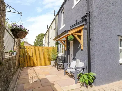 a patio with two chairs and a house at 8 Bridge Street in Cockermouth