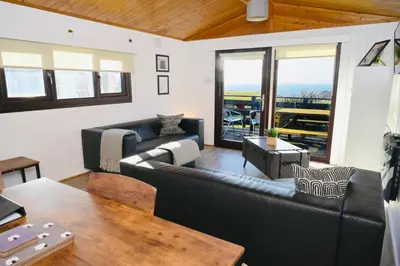 a living room with a couch and a table at Lodge Cabin with Fabulous Views - Farm Holiday in Stranraer