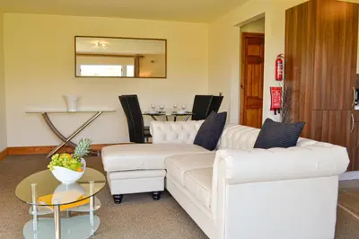 a living room with a white couch and a table at The Fairways in Portpatrick