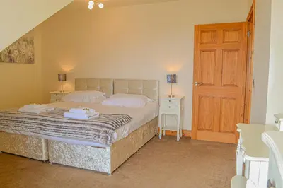 a bedroom with a bed with two towels on it at The Fairways in Portpatrick