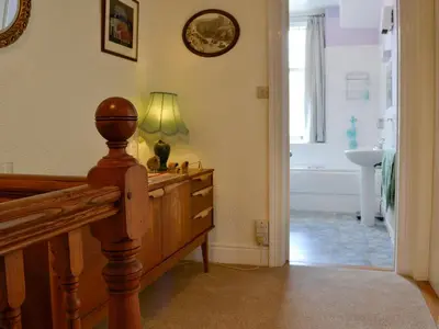a bedroom with a dresser with a lamp and a bathroom at Robinson in Keswick