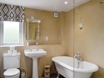 a bathroom with a sink and a toilet and a tub at Ramerish Retreat in Laurieston