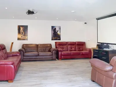 a living room with couches and a flat screen tv at Smithfield House in Tarbolton