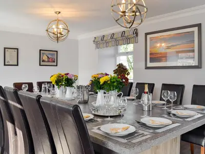 a dining room with a long table with chairs at Smithfield House in Tarbolton