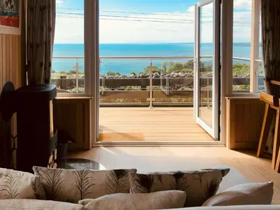 a living room with a couch and a large window at Little Oak - Uk5996 in Carsluith