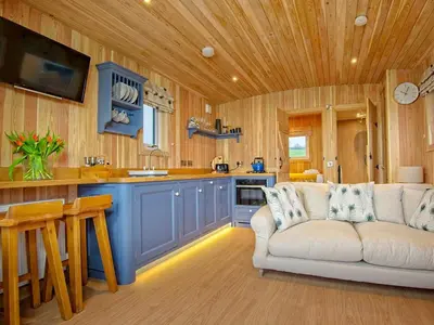 a living room with a couch and a kitchen at Little Oak - Uk5996 in Carsluith