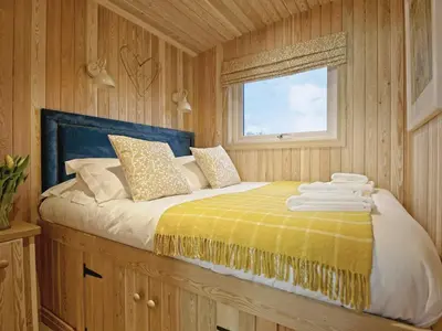 a bedroom with a bed with a yellow blanket and a window at Little Oak - Uk5996 in Carsluith