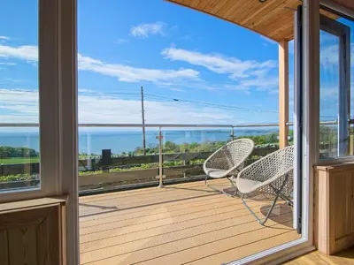 a balcony with two chairs and a view of the ocean at Little Beach - Uk5997 in Carsluith