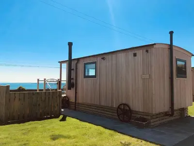 a small cabin with a fence in a yard at Little Beach - Uk5997 in Carsluith