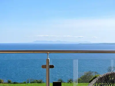 a view of the ocean from a balcony at Little Beach - Uk5997 in Carsluith