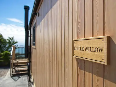 a wooden sign on the side of a building at Little Willow - Uk5998 in Carsluith