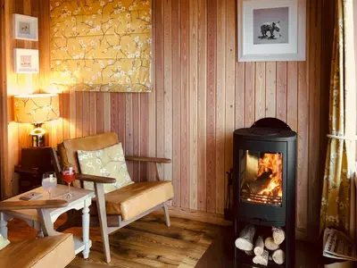 a living room with a wood stove and a chair at Little Willow - Uk5998 in Carsluith