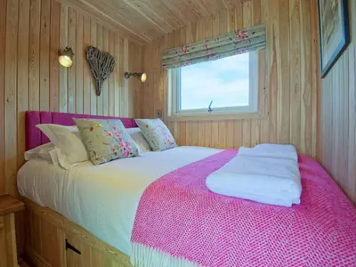 a bedroom with a large bed with a pink blanket at Little Willow - Uk5998 in Carsluith