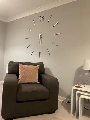 a clock on a wall next to a couch at No 7 Ayr Beach - Coorie Doon in Ayr