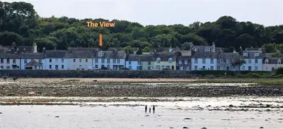 a row of houses on the shore of a beach at The View in Garlieston