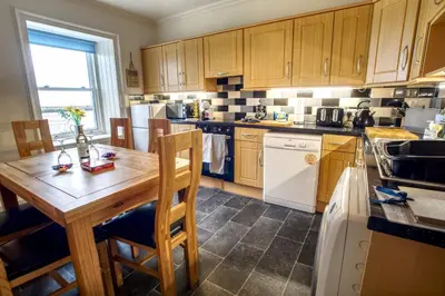 a kitchen with wooden cabinets and a wooden table at The View in Garlieston