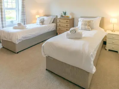 two beds in a bedroom with towels on them at Blair Terrace in Portpatrick