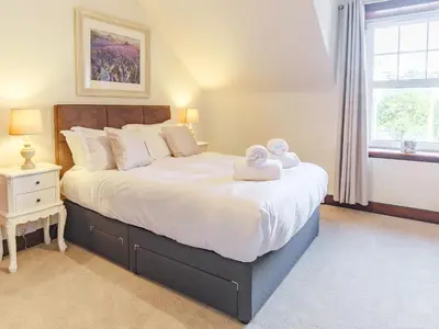 a bedroom with a large bed with towels on it at Blair Terrace in Portpatrick