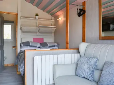 a living room with a couch and two beds at The Rocking Lodge in Threlkeld