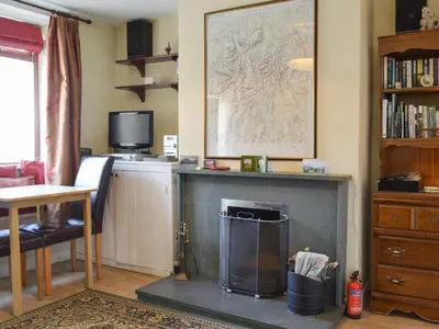a living room with a fireplace and a map on the wall at Causey View in Keswick