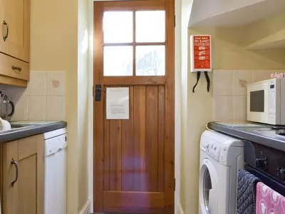 a kitchen with a door and a washing machine at Causey View in Keswick