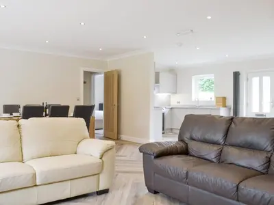 a living room with two couches and a kitchen at Lucy's At The Grange - Uk11519 in Mockerkin