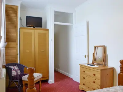 a bedroom with a bed and a dresser with a television on it at Lorna's At The Grange - Uk11565 in Mockerkin