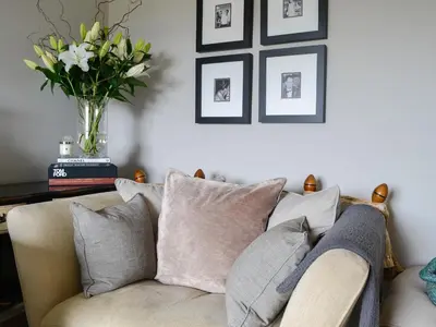 a living room with a couch with a vase of flowers at Woodend in Maxwelltown