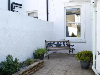a bench sitting on a porch next to a window at Wanderers Rest in Keswick