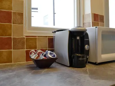a coffee maker and a cup next to a microwave at Wanderers Rest in Keswick