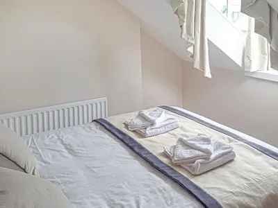 a bed with towels on it with a window at Wanderers Rest in Keswick