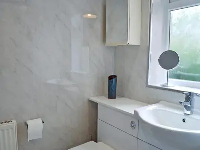 a bathroom with a sink and a toilet and a mirror at Tigh Beag in Troon