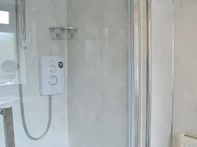 a shower in a bathroom with a glass shower backdoor at Tigh Beag in Troon