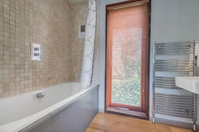 a bathroom with a tub and a sink and a window at Dobby Lodge in Bassenthwaite