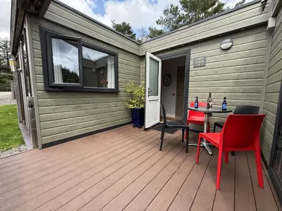 a wooden deck with a table and chairs on it at Dobby Lodge in Bassenthwaite