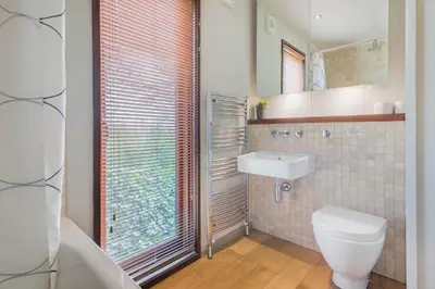 a bathroom with a toilet and a sink and a mirror at Dobby Lodge in Bassenthwaite