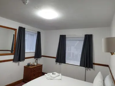 a hotel room with a bed and a window at Twa Dogs Inn in Keswick