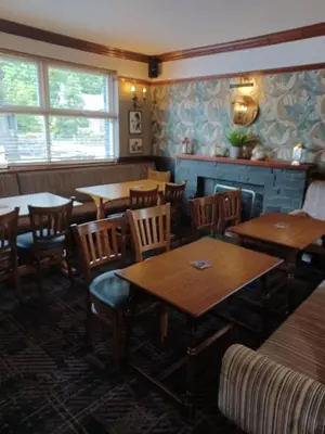 a dining room with wooden tables and chairs at Twa Dogs Inn in Keswick