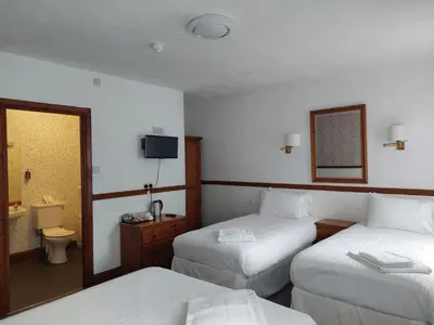 a hotel room with two beds and a mirror at Twa Dogs Inn in Keswick