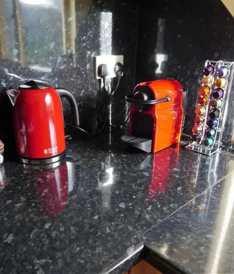 a counter top with a red coffee maker and a cup at Number 48 in Dumfries