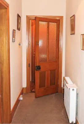 a hallway with a wooden door in a room at Number 48 in Dumfries